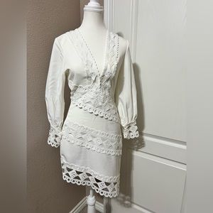 All white dress with elegant embellishment design and ornate cuffed sleeve